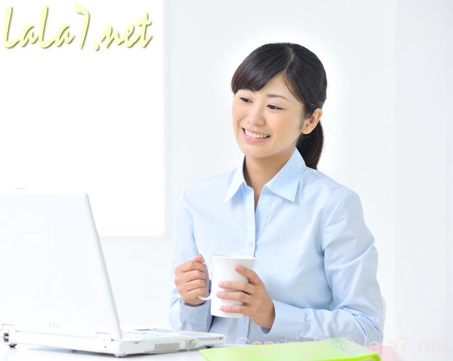 パソコンに向かう若い女性 微笑んでいる